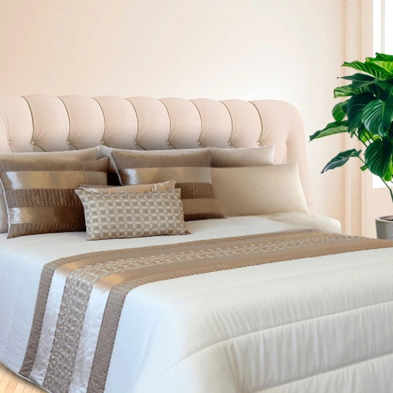 Edredón de invierno beige en habitación con luz, cabecero acolchado y planta - Algodonea