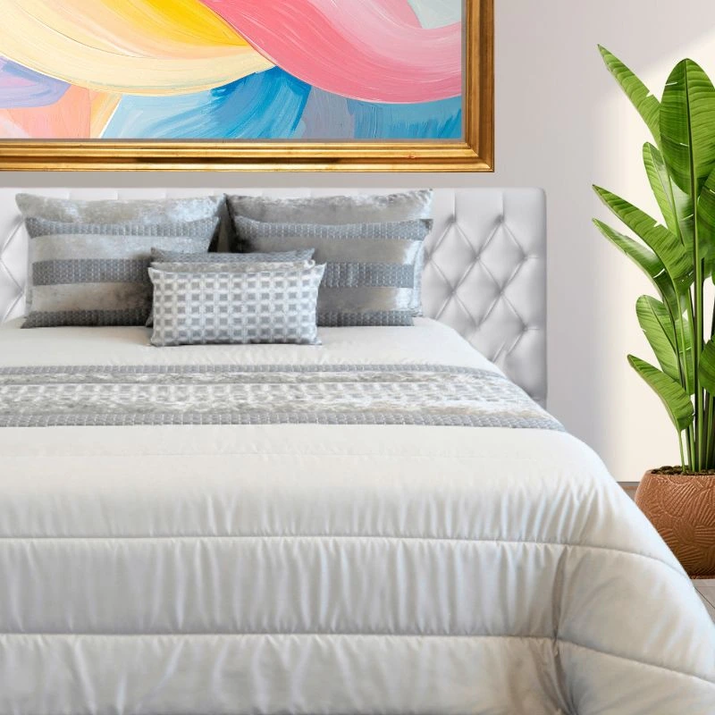 Edredón de invierno gris en habitación con cuadro de colores y planta verde - Algodonea