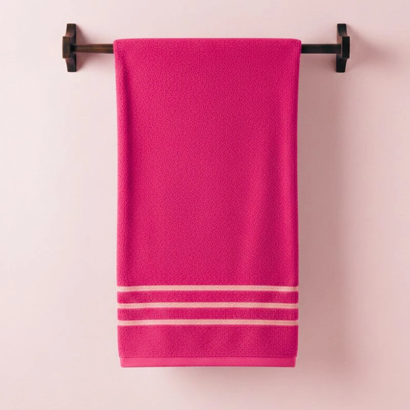 Toalla fucsia en un toallero negro - Algodonea textiles portugueses