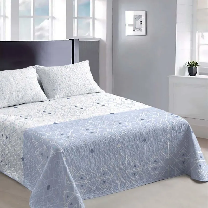 Colcha bouti de verano en tonos azules y blancos sobre una cama doble - Algodonea